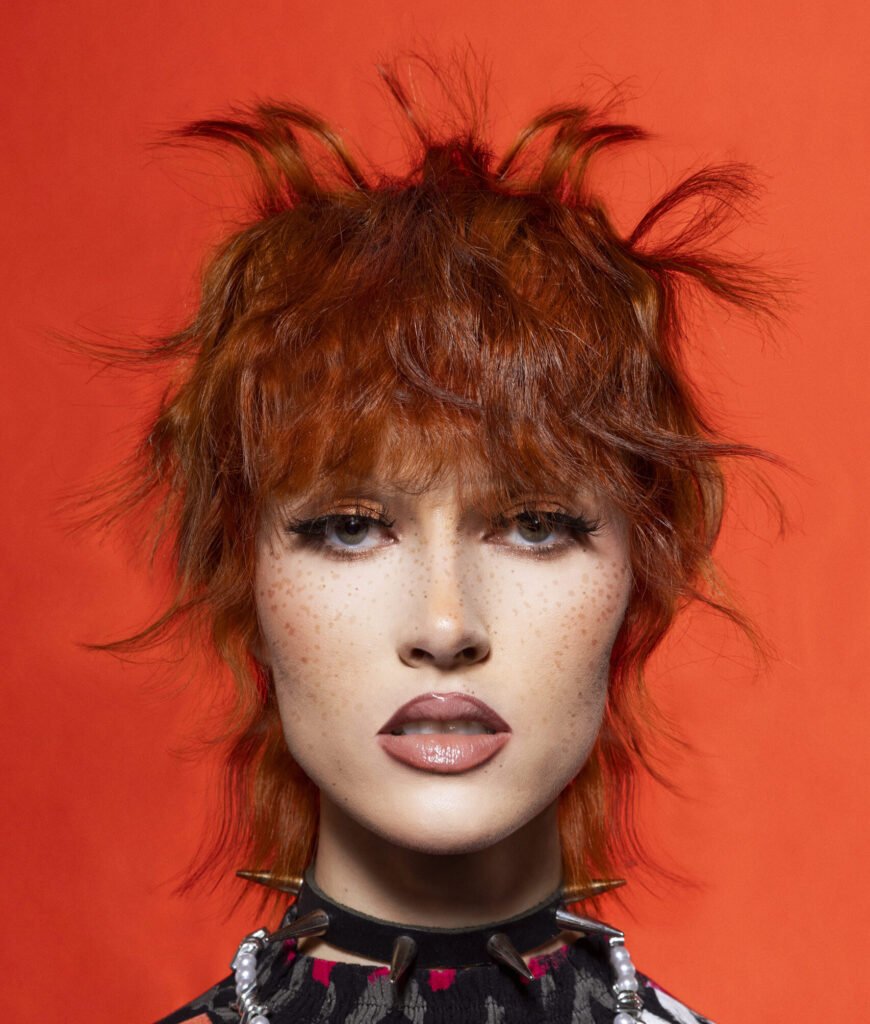 Model showcasing vibrant 80s-inspired hairstyle from the LIUJO Collection by Hairkrone Academy, celebrating the essence of peace, love, unity, and respect.