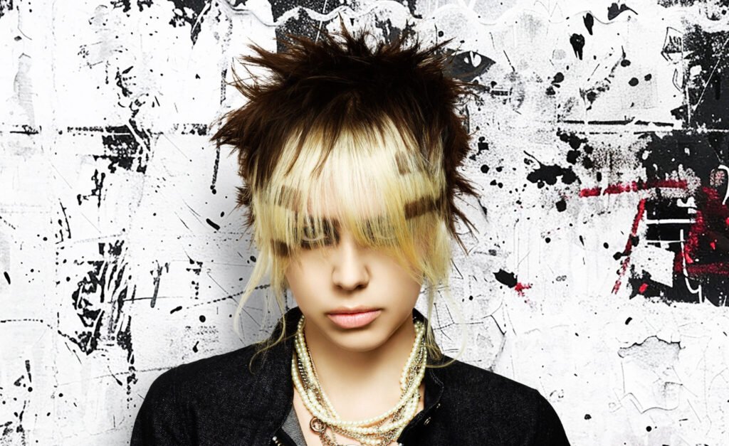 Model with a bold Neo Punk hairstyle featuring sharp, disconnected cuts and vibrant color blocks, from Daniel Benoit's collection in The Hair Magazine.