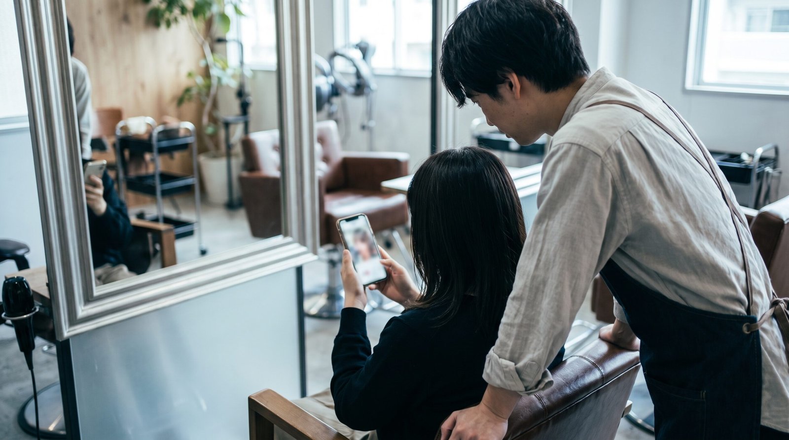 client holding a phone showing a reference image during consultation